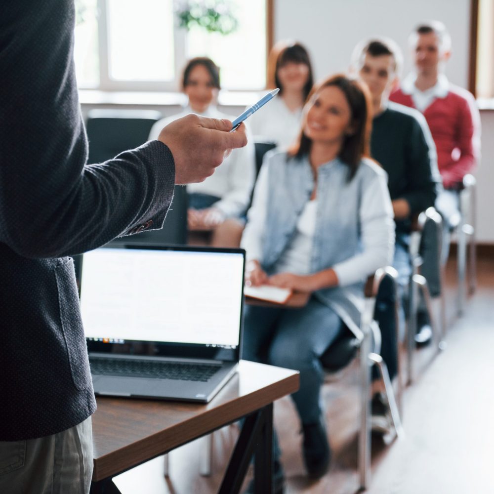 Everyone is smiling and listens. Group of people at business conference in modern classroom at daytime Everyone is smiling and listens. Group of people at business conference in modern classroom at daytime.